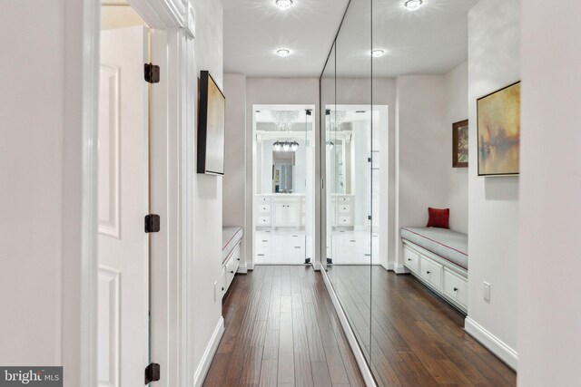 corridor featuring baseboards and dark wood-type flooring