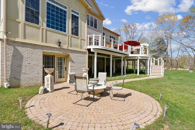 rear view of house featuring stairway, brick siding, a yard, and a patio area