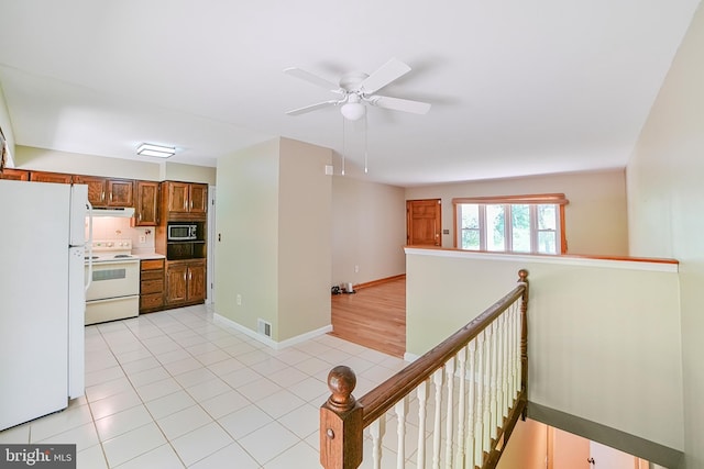 kitchen featuring white appliances, brown cabinetry, a ceiling fan, light tile patterned floors, and visible vents