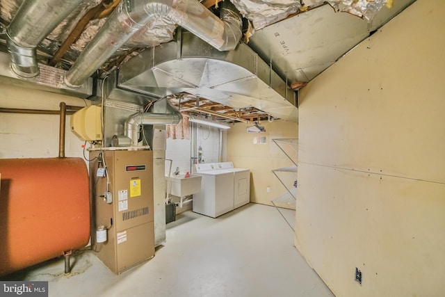 unfinished basement with heating unit, heating fuel, a sink, and washer and dryer