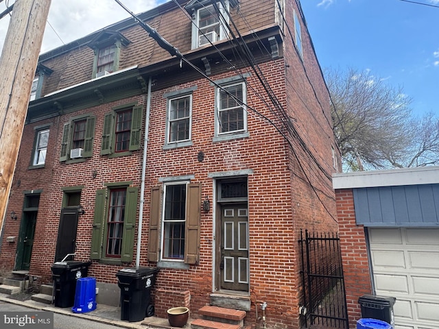 view of front of house featuring brick siding, cooling unit, fence, and entry steps