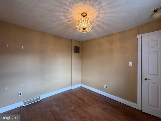 unfurnished room with a chandelier, baseboards, and visible vents