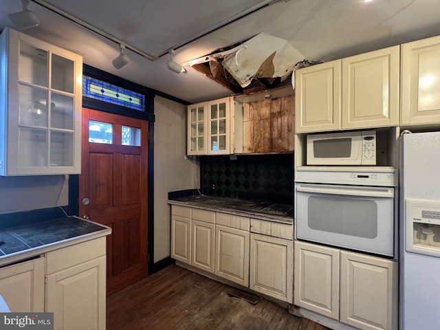 kitchen with white appliances, glass insert cabinets, dark wood-style floors, tile counters, and rail lighting
