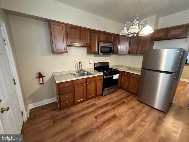 5934 Delancey St, Philadelphia, PA 19143 - kitchen with a sink, light countertops, a chandelier, dark wood-style floors, and stainless steel appliances