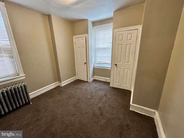 5934 Delancey St, Philadelphia, PA 19143 - unfurnished bedroom with dark carpet, baseboards, and radiator