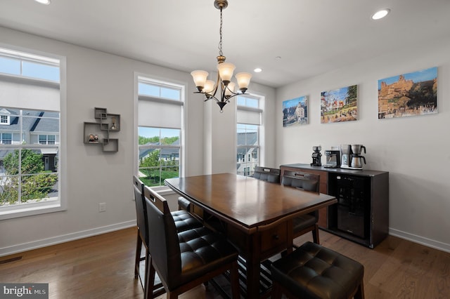 dining area featuring recessed lighting, dark wood-type flooring, baseboards, and a notable chandelier
