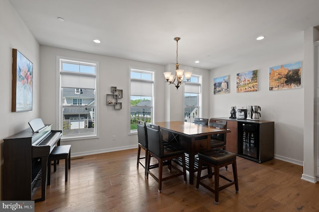 dining room with an inviting chandelier, recessed lighting, baseboards, and wood finished floors
