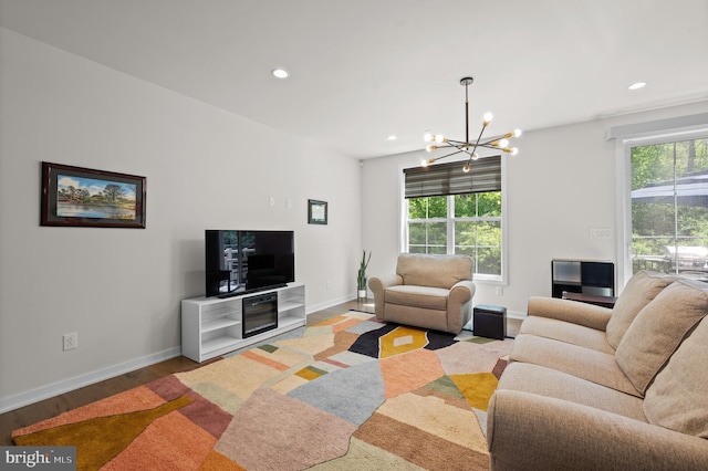 living room with a notable chandelier, baseboards, and a healthy amount of sunlight