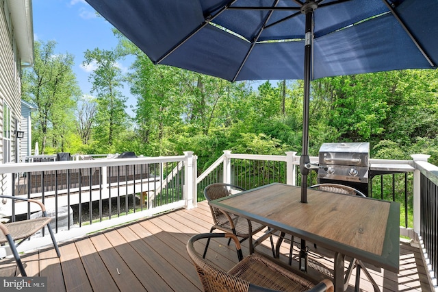 wooden terrace featuring area for grilling and outdoor dining space