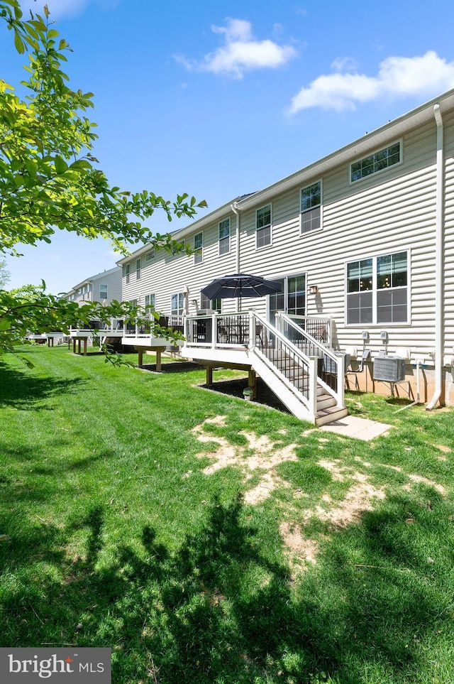 back of property featuring a gazebo, a lawn, and central AC