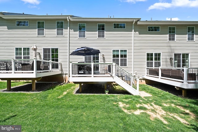 rear view of property featuring a yard and a wooden deck