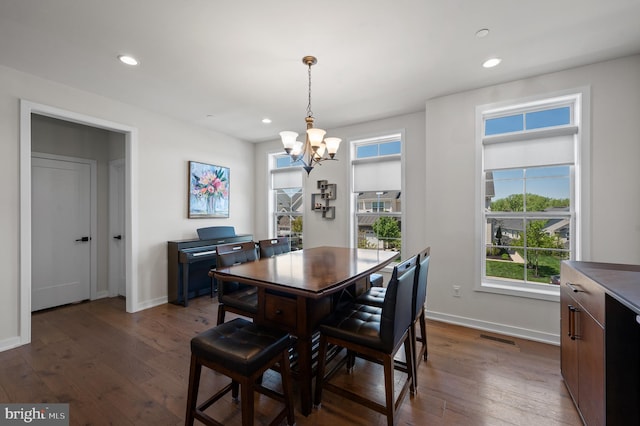 dining area featuring plenty of natural light, a chandelier, and dark wood-type flooring