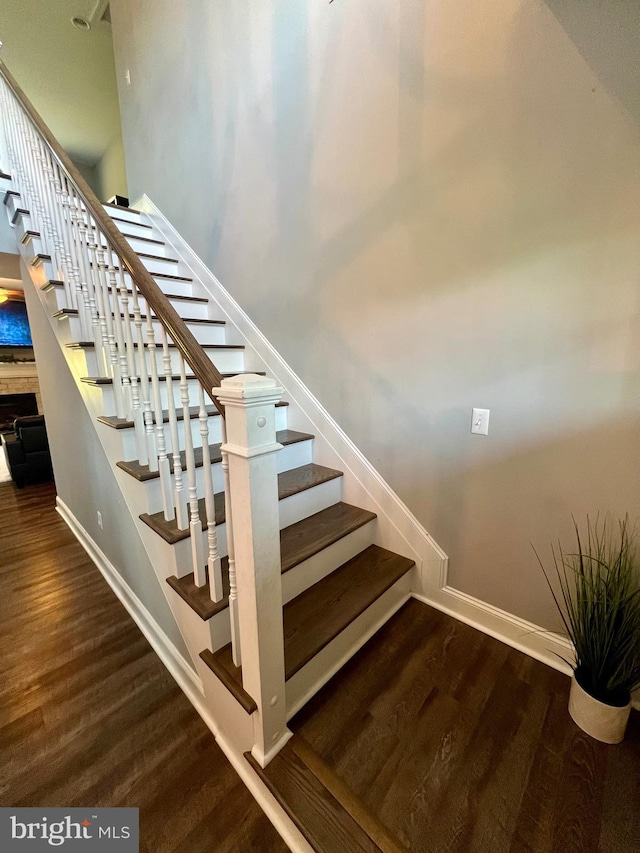 staircase featuring baseboards and wood finished floors