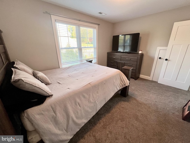 carpeted bedroom featuring visible vents