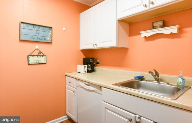 kitchen with white dishwasher, a sink, white cabinetry, and light countertops