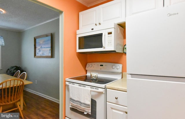 kitchen featuring dark wood-type flooring, ornamental molding, white cabinets, and white appliances