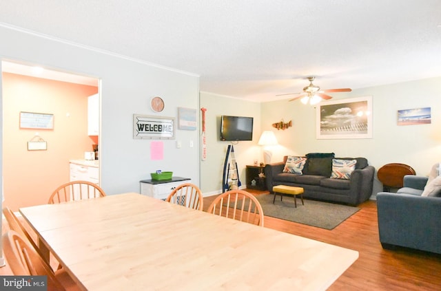dining space with light wood finished floors and ceiling fan