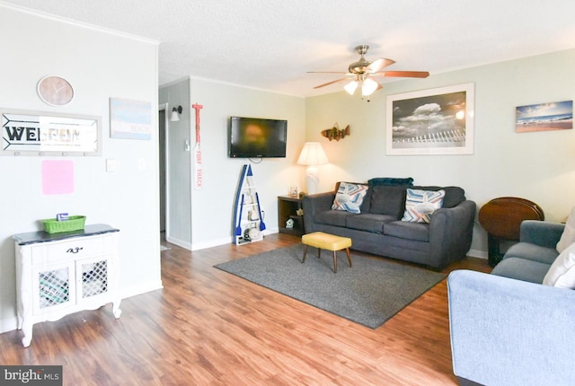 living room with baseboards, ceiling fan, and wood finished floors