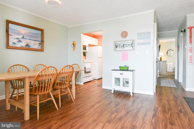 dining space with baseboards, ornamental molding, and wood finished floors