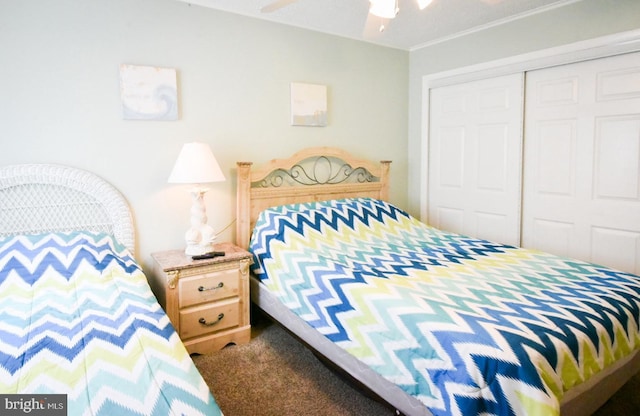 bedroom with carpet flooring, a ceiling fan, crown molding, and a closet