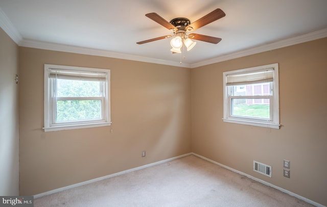 empty room featuring crown molding, ceiling fan, carpet, visible vents, and baseboards