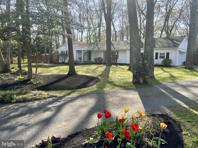 single story home featuring fence, a front lawn, and a garage