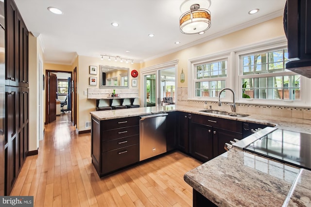 kitchen featuring stainless steel dishwasher, a sink, backsplash, a peninsula, and ornamental molding