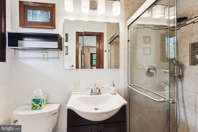 bathroom with a shower stall, toilet, and vanity