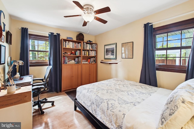 bedroom with a ceiling fan and light wood-type flooring