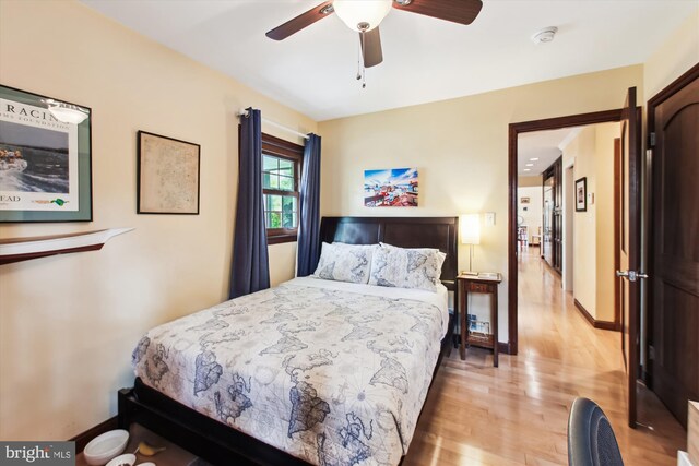 bedroom with a ceiling fan, baseboards, and light wood-style floors
