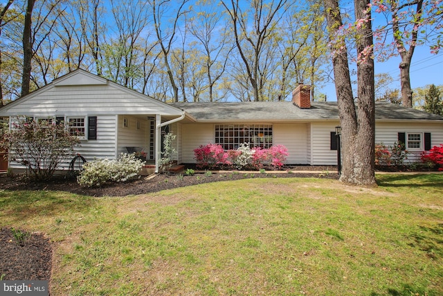 single story home featuring a chimney and a front lawn
