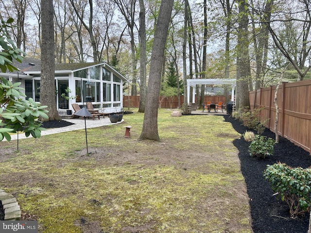 view of yard featuring a fenced backyard, a sunroom, and a patio