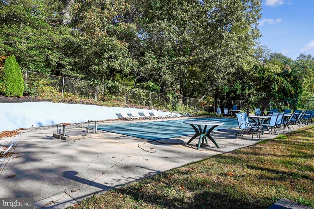 community pool featuring fence and a patio area