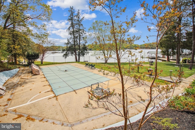 view of swimming pool with fence, a water view, a patio area, and a fenced in pool