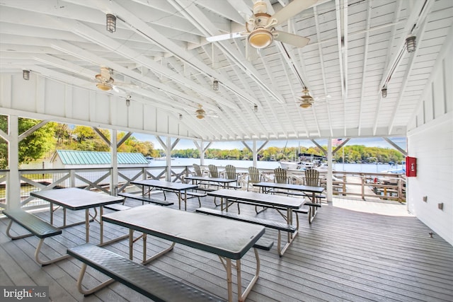 wooden deck with a ceiling fan and a water view