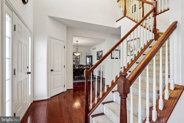 entrance foyer with wood-type flooring, stairway, and baseboards