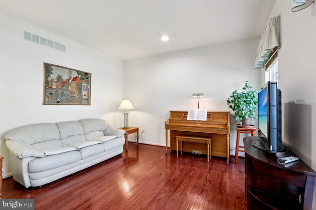 living room featuring baseboards, visible vents, wood finished floors, and recessed lighting