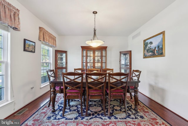 dining area with visible vents, wood finished floors, and baseboards