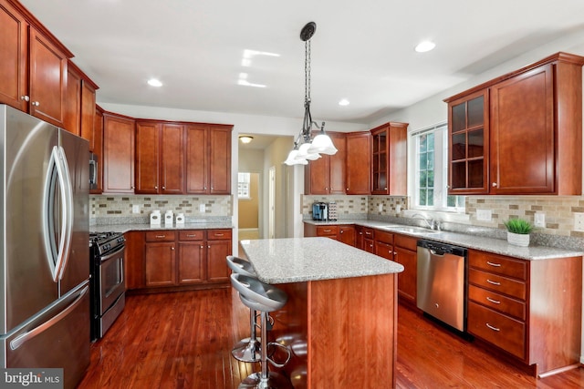 kitchen featuring dark wood-type flooring, stainless steel appliances, and backsplash