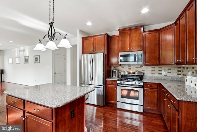 kitchen with appliances with stainless steel finishes, dark wood-style flooring, light stone countertops, and decorative backsplash
