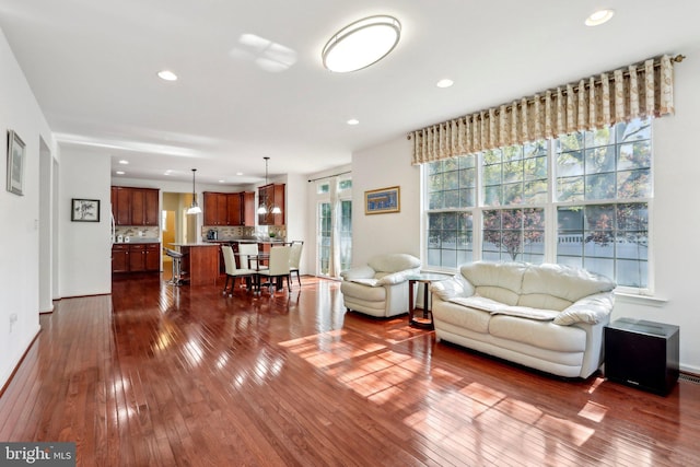 living area with baseboards, recessed lighting, and dark wood-style flooring
