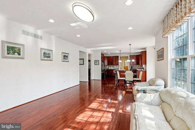living room with dark wood finished floors, recessed lighting, and visible vents
