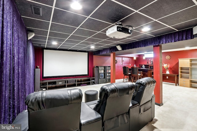 carpeted home theater room featuring a drop ceiling, bar, and visible vents