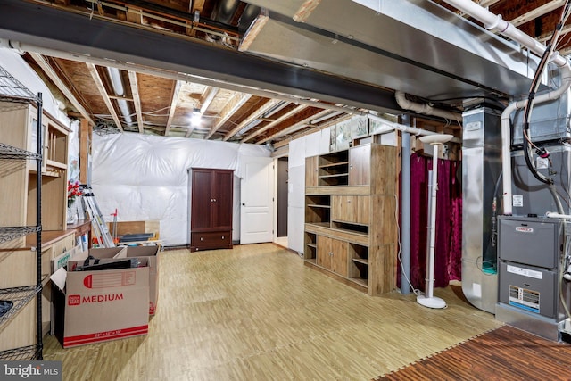 unfinished basement with wood finished floors and heating unit