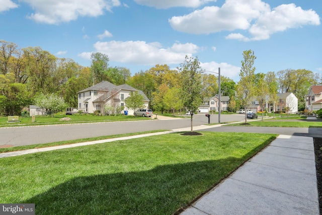 view of street featuring sidewalks, a residential view, and street lights