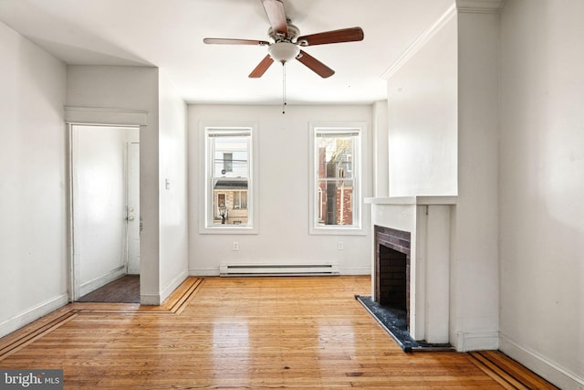 2333 E Huntingdon St, Philadelphia, PA 19125 - unfurnished living room with baseboard heating, baseboards, a fireplace, light wood-style flooring, and ceiling fan