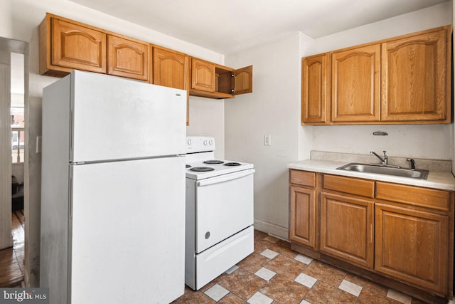 2333 E Huntingdon St, Philadelphia, PA 19125 - kitchen featuring a sink, brown cabinetry, light countertops, and white appliances