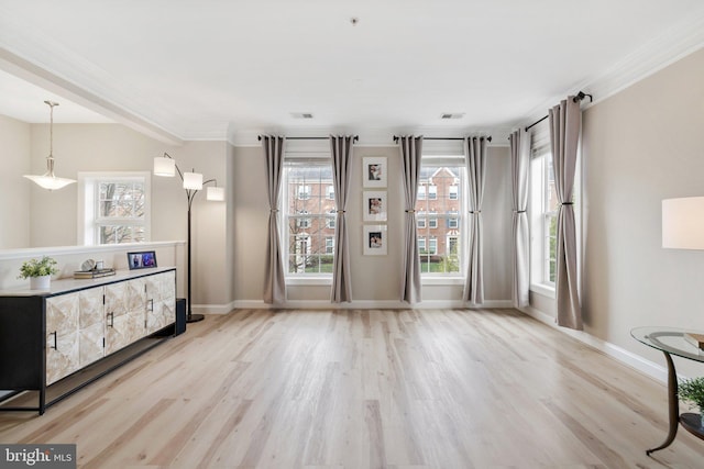 living area with baseboards, visible vents, ornamental molding, and wood finished floors