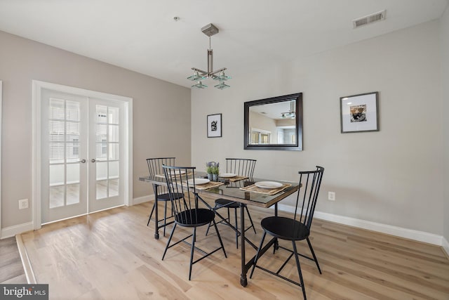 dining space featuring baseboards, visible vents, and light wood finished floors