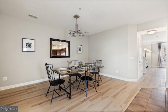 dining area featuring baseboards, wood finished floors, and visible vents